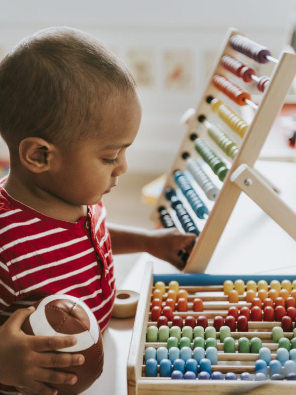 Kid playing with a colorful wooden abacus